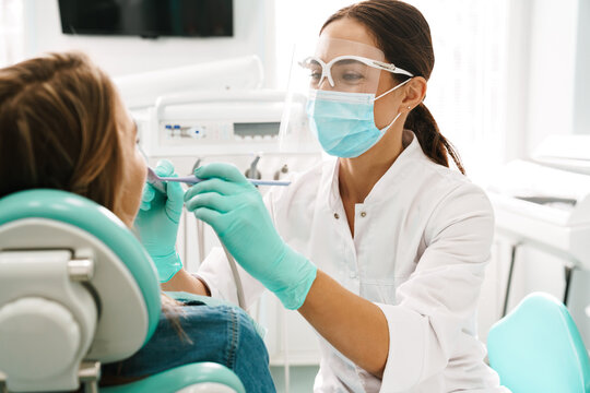 European Mid Dentist Woman In Face Mask Working In Dental Clinic