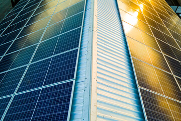 Aerial view of surface of blue photovoltaic solar panels mounted on building roof for producing...
