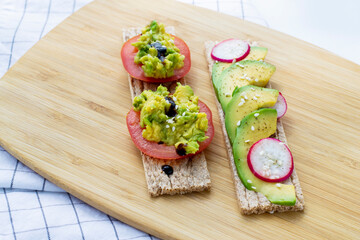 Healthy snack. Snack with avocado and tomato. Bruschetta with tomatoes, avocado and radish.