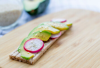 Healthy snack. Snack with avocado and radish. Bruschetta with radish and avocado.