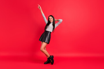 Full length photo of charming stunning young woman point finger up dance party isolated on red color background