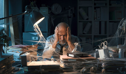 Desperate businessman sitting in his abandoned office
