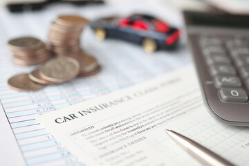 Car insurance contract, along with calculator and pen, lies on table