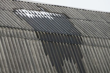 part of a private rural house from a gray slate roof in white wet snow