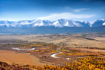 Scenic aerial view over Chuya river in Kuray steppe with snow capped mountain range on the background. Altai autumn landscape, Russia