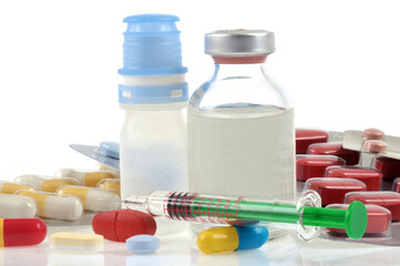 Traitement médical avec divers médicaments et une seringue en gros plan sur fond blanc