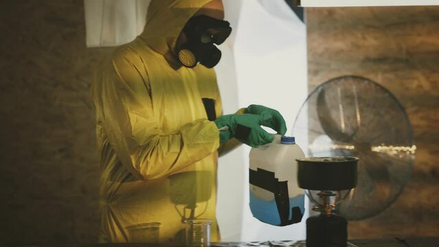 Illegal chemist cooks drugs in underground laboratory wearing mask and works with toxic chemical compounds