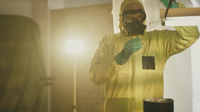 Illegal chemist cooks drugs in underground laboratory wearing mask and works with toxic chemical compounds