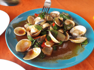 Seashells cooked in Thai sauce. Pan-Asian cuisine.