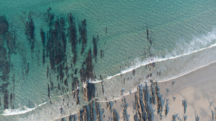 aerial view of the beach with some lines of rocks