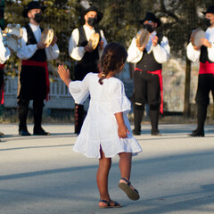 child dancing to a traditional group of musicians