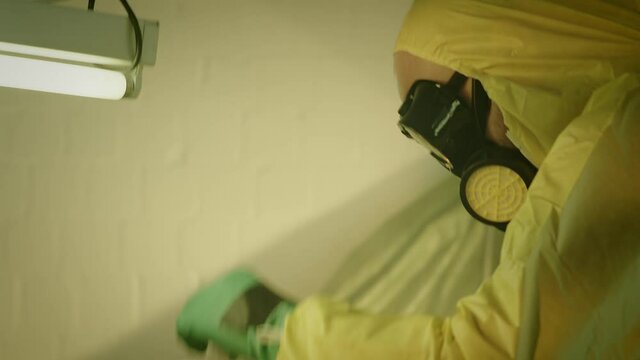 Illegal chemist cooks drugs in underground laboratory wearing mask and works with toxic chemical compounds