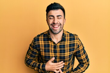 Young hispanic man wearing casual clothes smiling and laughing hard out loud because funny crazy...