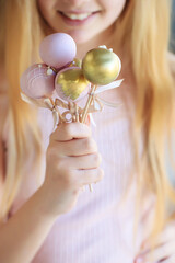 The pastry chef decorates cake pops with satin ribbons.Various cake pops decorated with white and dark chocolate on a brown background. High quality photo.