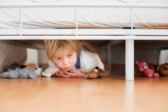 Little Toddler Child, Hiding Under The Bed With Stuffed Toys, Scared