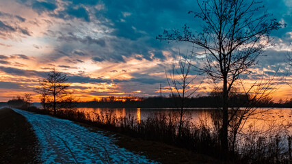 Beautiful sunset with reflections and dramatic clouds near Plattling, Isar, Bavaria, Germany