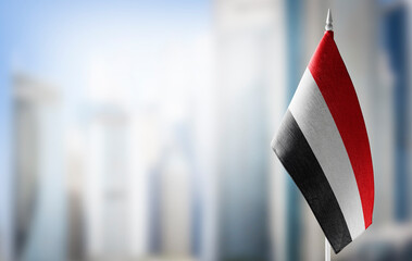 A small flag of Yemen on the background of a blurred background