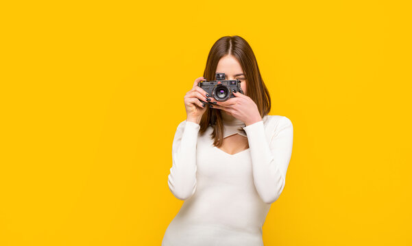Woman holding camera over yellow background. Girl using a camera photo. Photographer  camera photo, photographing girl joy make photography taking concept. Girl  with a cameras Stock Photo | Adobe Stock