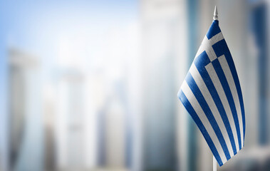 A small flag of Greece on the background of a blurred background