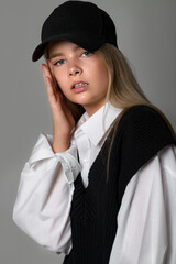 Fashionable teenager girl in the studio. The girl follows fashion and dresses stylishly. High quality photo.