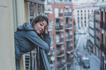 Young beautiful woman looking sad and depressed on a balcony in a depression concept.