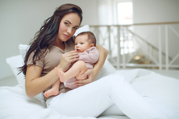 Fototapeta na wymiar A young mother is holding her newborn baby. Mother of a nursing baby. Mother breastfeeding her baby. The family is at home. Portrait of a happy mother and child. High quality photo.