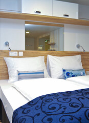 Twin double queen bed with decoration pillows and duvet inside large interior inside stateroom or...