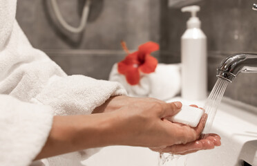 Close up of a girl washes her hands with soap in the bathroom.