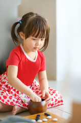 little cute asian girl focusing to play on her baduk (GO) board game