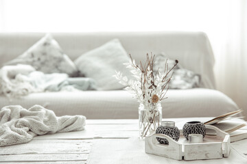 Fototapeta na wymiar Home arrangement with candlesticks, twigs in a vase and Scandinavian decor details.