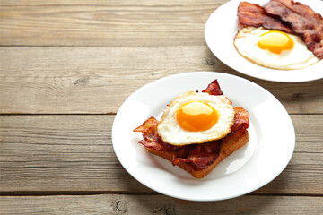 Eggs and bacon for breakfast on grey background. English breakfast with copy space.