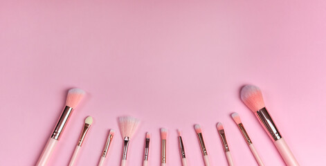 set of makeup brushes on a pink background