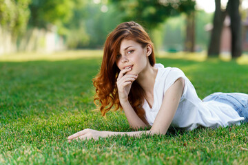 woman lies in the park on the lawn in the fresh air
