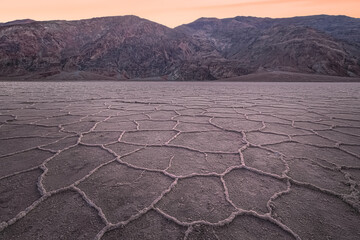 Fototapeta premium Beautiful, inspiring landscape and halcite texture of Badwater Basin salt flats during a golden sunset or sunrise at Death Valley National Park, USA.
