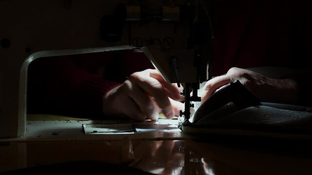 Sewing machine and men's hands of a tailor