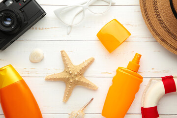 Sunscreen bottle with hat, glasses and other accessories on white background. Cosmetics for safe sunburn. Top view, flatlay. Sun protection cream