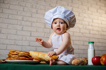 Little chef. Little kid dressed as a chef with pastries, buns, bread