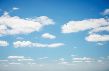 Azure sky background with white fluffy clouds in the fresh sunny day.