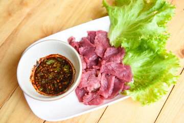 beef meat salad, fresh raw beef slice on plate with spicy sauce and vegetables lettuce - thai food