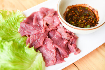 beef meat salad, fresh raw beef slice on plate with spicy sauce and vegetables lettuce - thai food