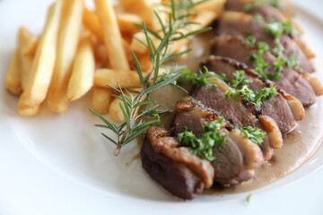 Duck magret confit with chips on wood table