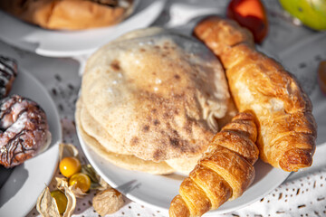 Close up of tortilla and croissant on a plate.