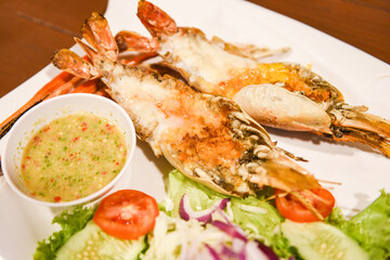 Grilled shrimp cut half with fresh vegetable and seafood sauce, Giant river prawn shrimp grilled serve on white plate