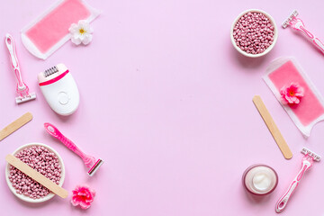 Fototapeta na wymiar Flat lay of pink epilator with wax strips and razor. Spa cosmetic treatments.