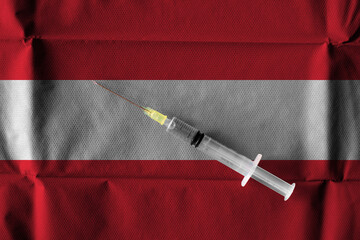 Concept of the ongoing efforts by Austria to deliver and distribute COVID-19 Vaccine with a syringe ready to use on an Austrian Flag.