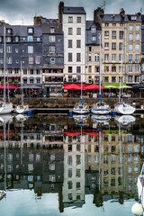 Honfleur, Normandy / France - August 27, 2020. World heritage in Calvados, Normandy, France. Panoramic view of the picturesque harbour of Honfleur, yachts and old houses reflected in water.