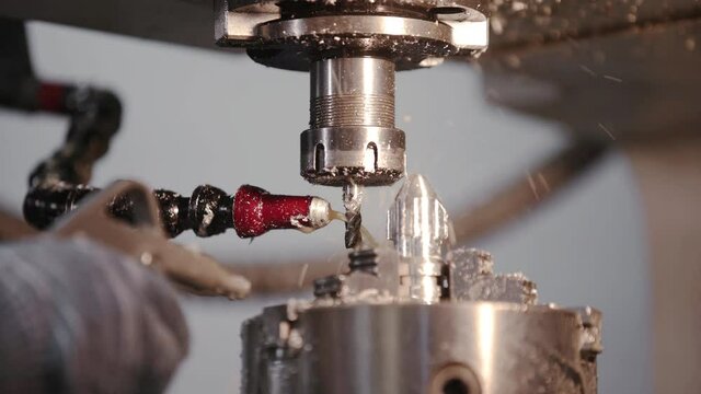 Produces metal detail in factory. Machine tools for metal working. A metal workpiece is machined by an electric machine. Cutting metal modern processing technology. Coolant and lubrication.