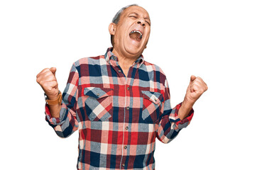 Senior hispanic man wearing casual clothes very happy and excited doing winner gesture with arms raised, smiling and screaming for success. celebration concept.