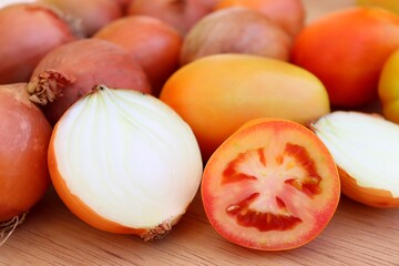 Tomatoes and onions on wooden background. Salad concept.