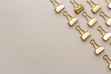 Office supplies pattern. Golden paper binder clips